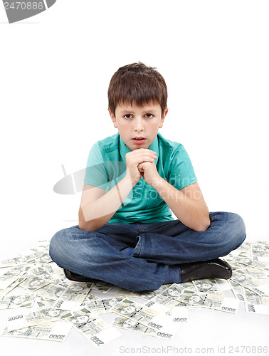 Image of boy sitting on money