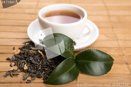 Image of A cup of green tea with freh leaves
