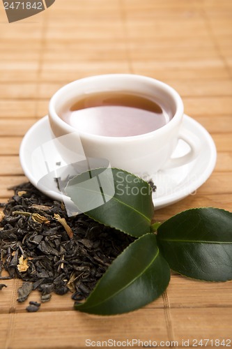 Image of A cup of green tea with freh leaves