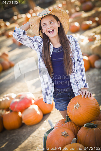 Image of Preteen Girl Playing with a Wheelbarrow at the Pumpkin Patch
