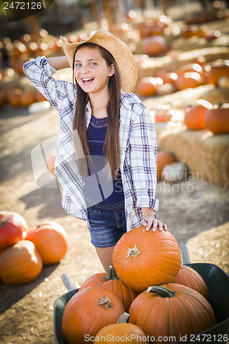 Image of Preteen Girl Playing with a Wheelbarrow at the Pumpkin Patch
