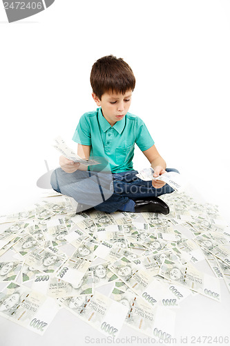 Image of boy sitting on money