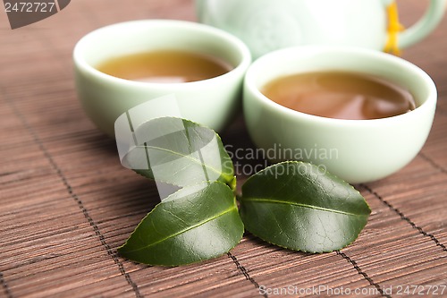 Image of A cup of green tea with freh leaves