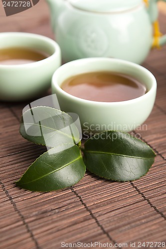 Image of A cup of green tea with freh leaves