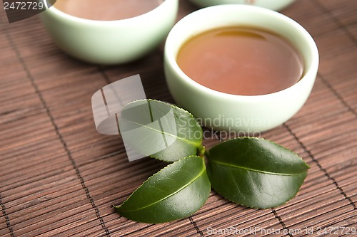 Image of A cup of green tea with freh leaves