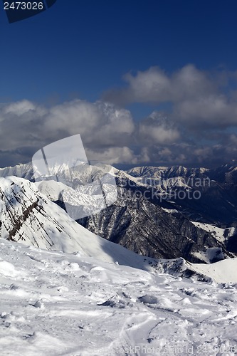 Image of Sunlit mountains in clouds, view from off-piste slope