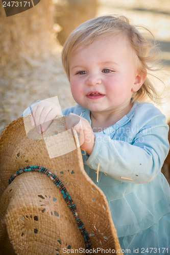 Image of Adorable Baby Girl with Cowboy Hat at the Pumpkin Patch
