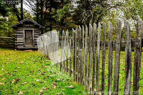 Image of Beautiful Autumn scene showing rustic old log cabin surrounded b