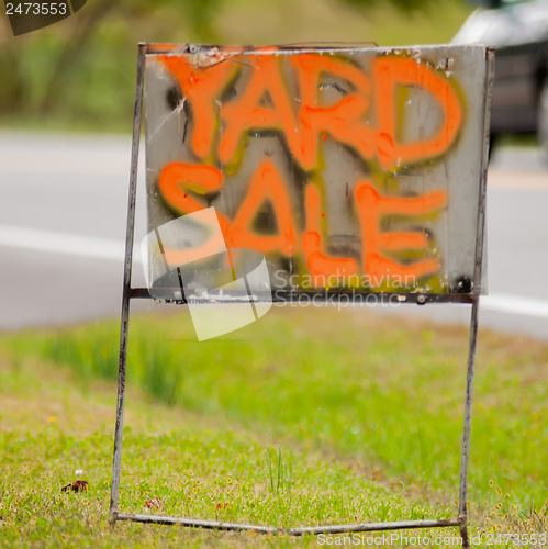 Image of orange handwriting yard sale sign