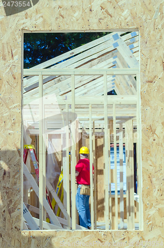 Image of wood frame construction job seen trhough window opening