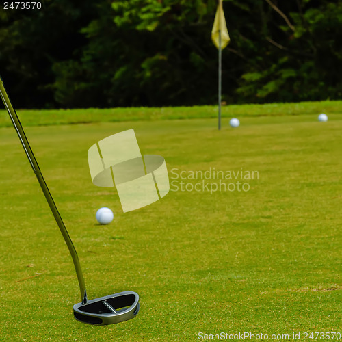 Image of Golf ball on a green, in front of the hole,