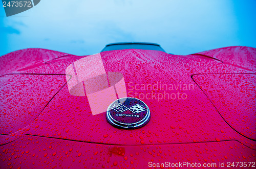 Image of red sports car wet from rain drops