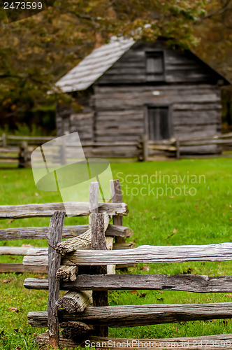 Image of Beautiful Autumn scene showing rustic old log cabin surrounded b