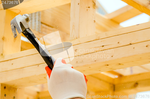 Image of worker hammering nails to wood studs