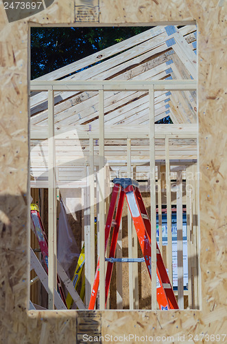 Image of wood frame construction job seen trhough window opening