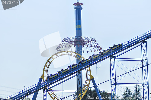 Image of rollercoasters at an amusement park with blue sky