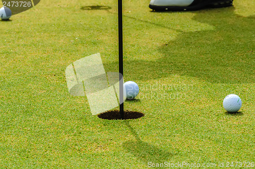 Image of golfer putting a golf ball in to hole