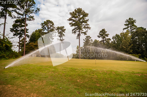 Image of watering green grass lawn on golf course