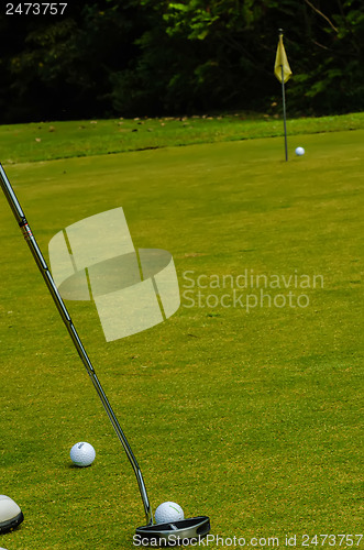 Image of Golf ball on a green, in front of the hole,