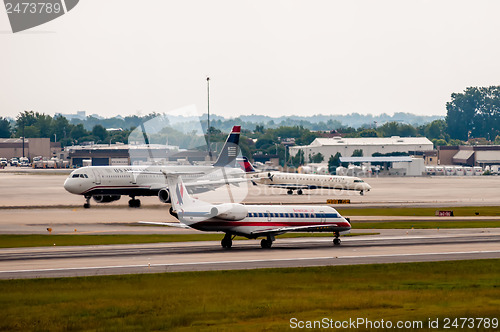 Image of Commercial jet on an airport runway with city skyline in the bac