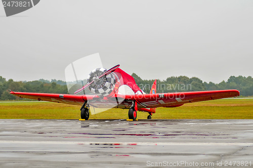 Image of  red aerobatics plane parked due to rain