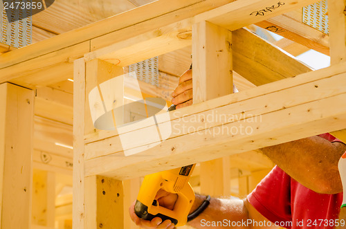 Image of Building contractor worker using a reciprocating saw to cut 