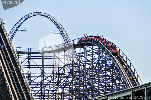 Image of rollercoasters at an amusement park with blue sky