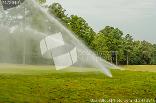 Image of watering green grass lawn on golf course