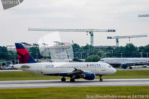 Image of Commercial jet on an airport runway with city skyline in the bac