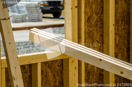 Image of stack of wood stud planks at construction site resting on window