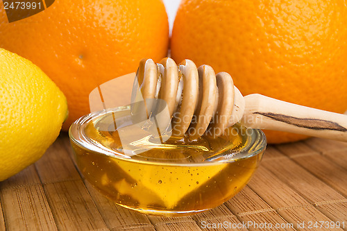 Image of fresh honey with lemon and orange fruits