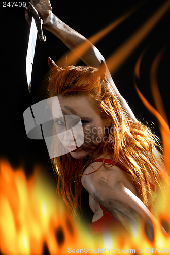 Image of red devil girl with a knife in fire