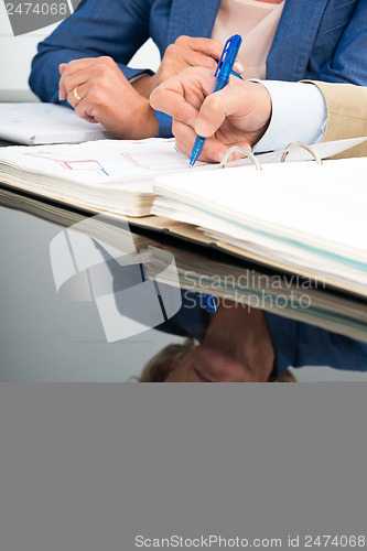 Image of Business woman reflected in desk