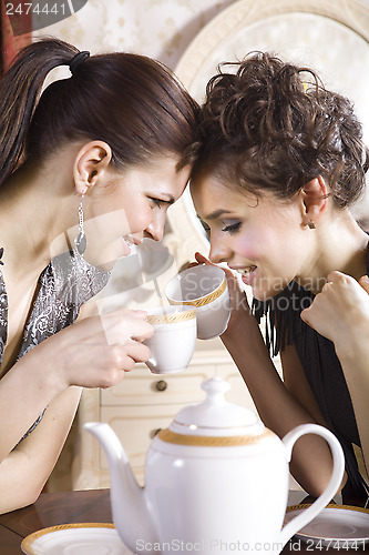 Image of Happy girl-friends with cups