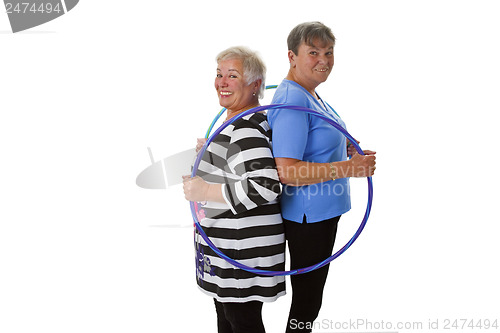 Image of Senior lady doing gymnastic with hula hoop