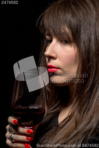 Image of Young woman with red wine from a glass