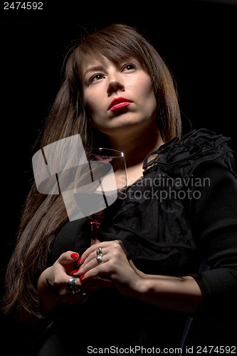 Image of Young woman with red wine from a glass