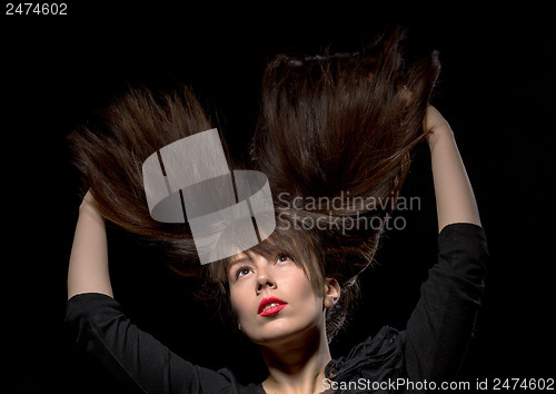 Image of Young woman with her hair flying in the air