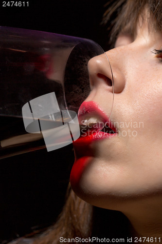 Image of Young woman drinking red wine from a glass