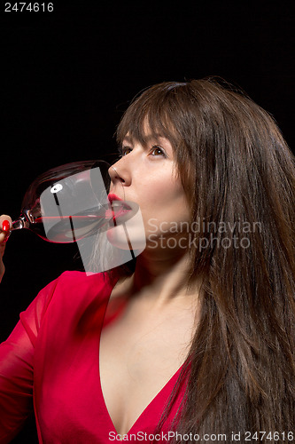 Image of Young woman drinking red wine from a glass