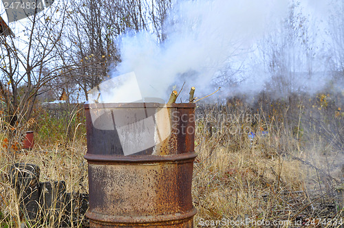 Image of Smoke from a barrel with garbage on a country site