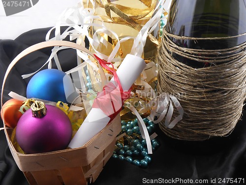 Image of bottle of champagne, christmas balls and white invitation paper