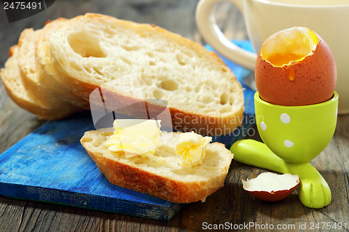 Image of White bread with butter and egg in a stand.