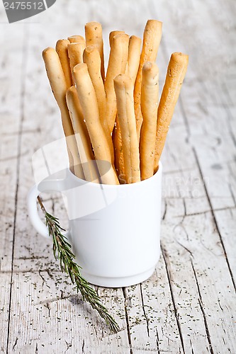 Image of cup with bread sticks grissini and rosemary