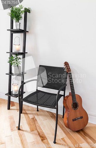 Image of Room with simple furniture, plants and guitar