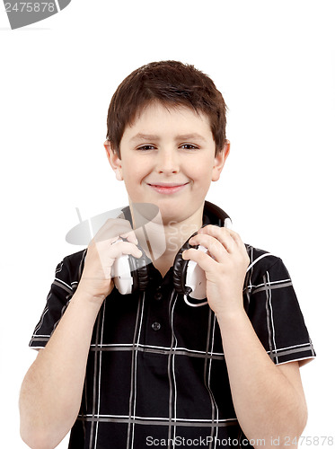 Image of Portrait of a happy smiling young boy listening to music on head