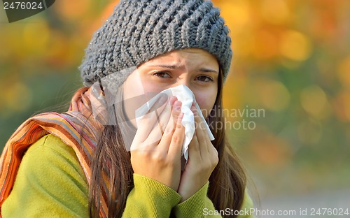 Image of girl with allergy or cold using tissue