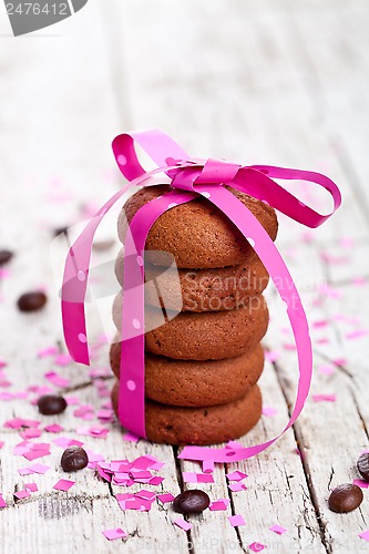 Image of cookies tied with pink ribbon, confetti and coffee beans