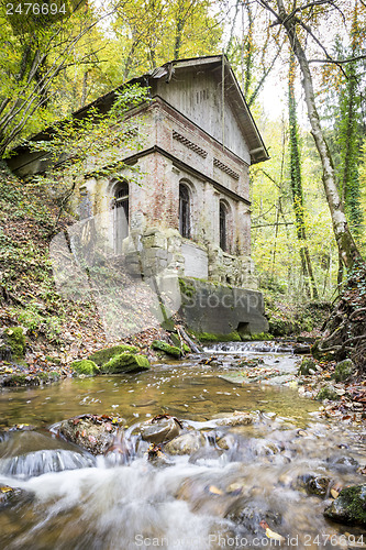 Image of old house with creek in forest