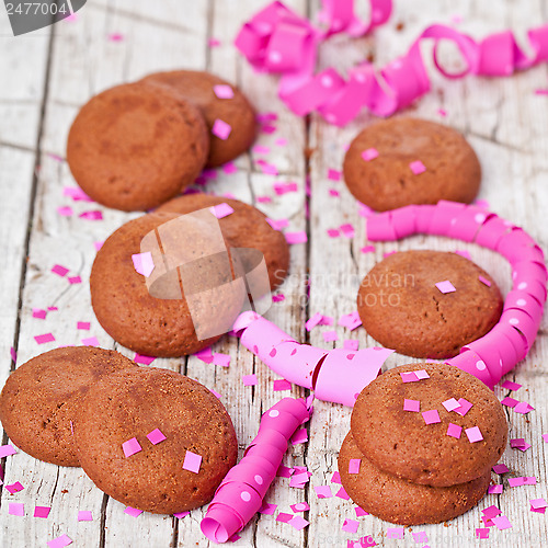 Image of fresh chocolate cookies, pink ribbons and confetti 